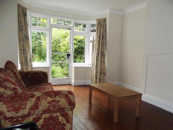 Bright living room with large windows to garden...