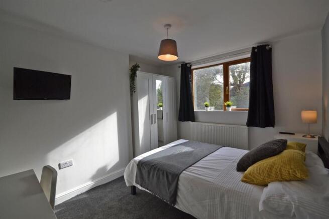 Bright modern bedroom with double bed and TV...