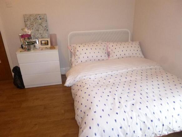 Cozy double bedroom with a neatly made bed, sim...