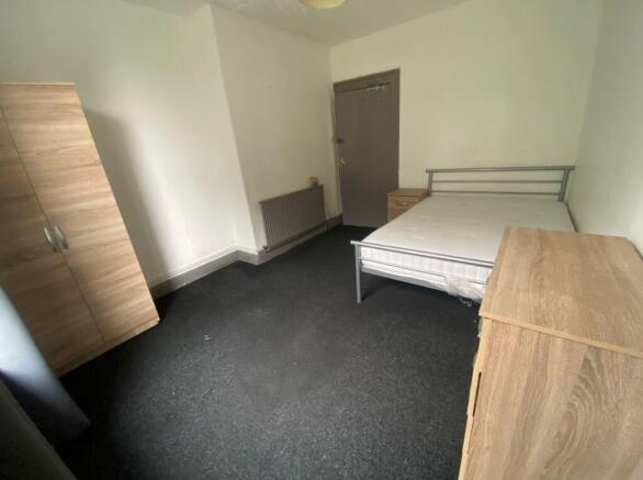 A tidy double bedroom featuring a sturdy metal ...