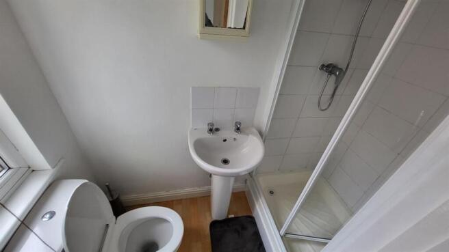 Compact, modern bathroom with a corner shower c...