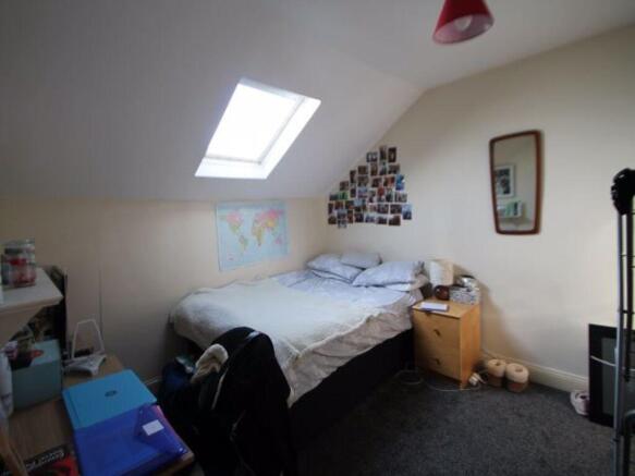 A cozy attic bedroom featuring a skylight that ...