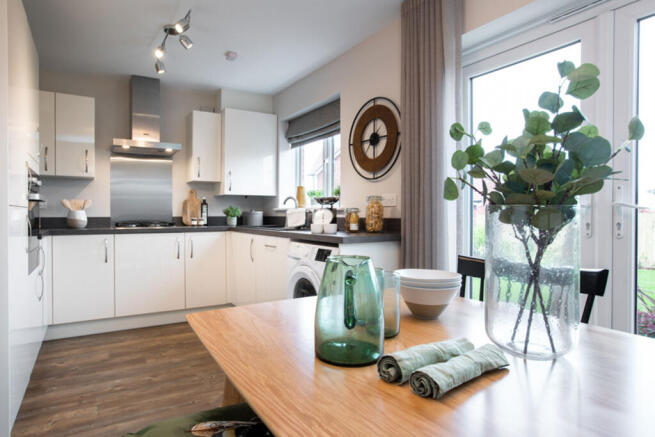 A modern, well-lit kitchen with white cabinets, wooden countertops