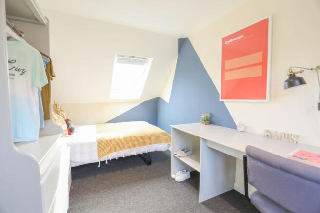 This inviting double bedroom features a cozy at...