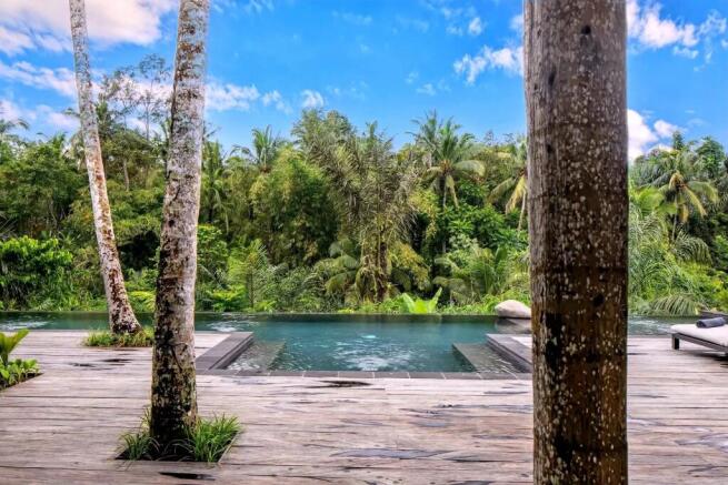 A tranquil poolside setting with a wooden deck sur