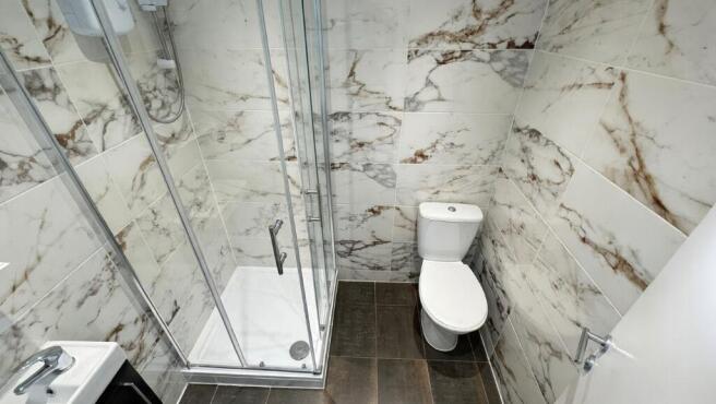 Modern bathroom with a glass-enclosed shower, s...