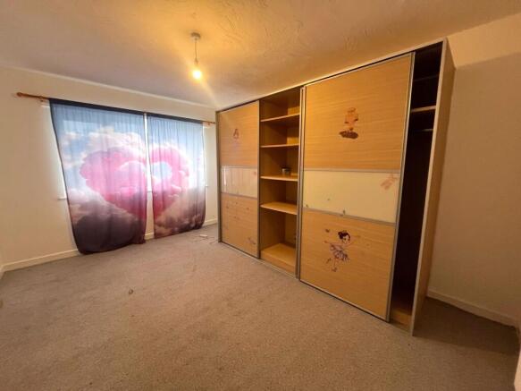 Bright double bedroom with large window dressed...