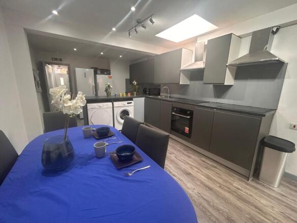 Modern shared kitchen with dining table and isl...