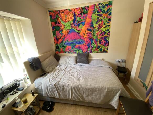 Bright bedroom with large bed and colorful art...