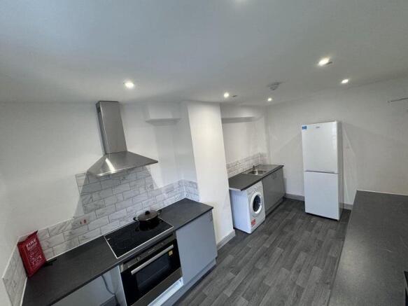 Modern kitchen with sleek grey countertops, sta...