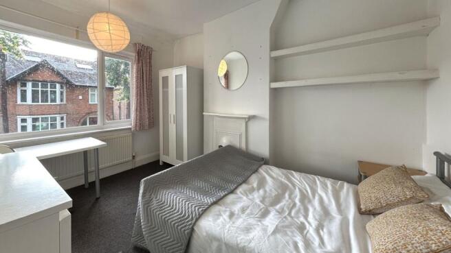 A bright and inviting bedroom with a large wind...