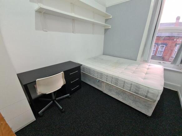 A bright, tidy bedroom featuring a single bed b...