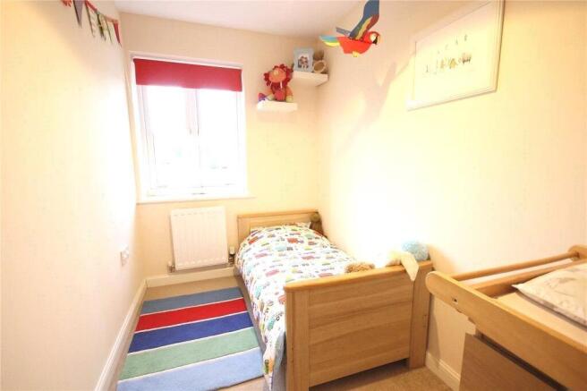 Cozy single bedroom featuring a comfortable woo...