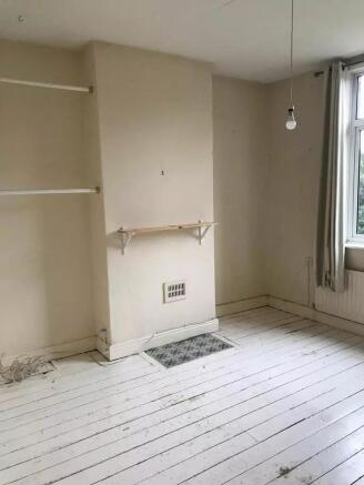 A modestly sized bedroom with natural light com...