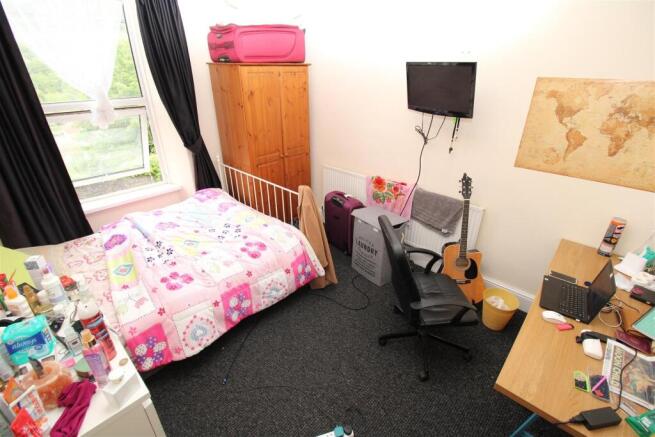 Bright bedroom with large window and study desk...
