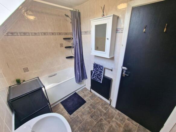 Bright, well-kept bathroom with a white bathtub...