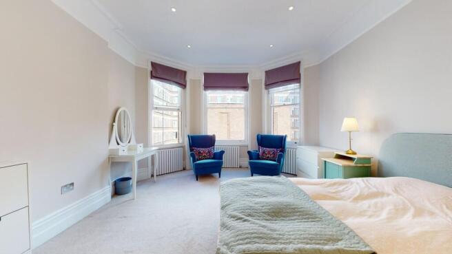 Bright and spacious master bedroom featuring a ...
