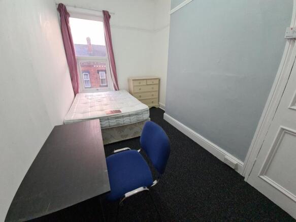 A compact bedroom featuring a double bed and a ...