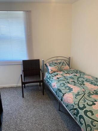 Bright bedroom with patterned bedding and windo...