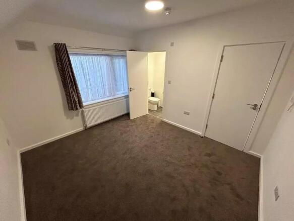 Spacious double bedroom with a large window pro...