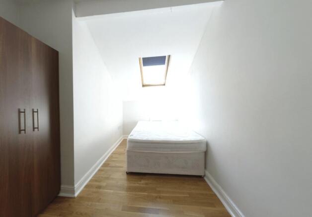 A bright, neatly maintained small bedroom with ...