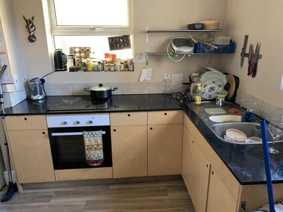 Compact L-shaped kitchen with integrated oven, ...