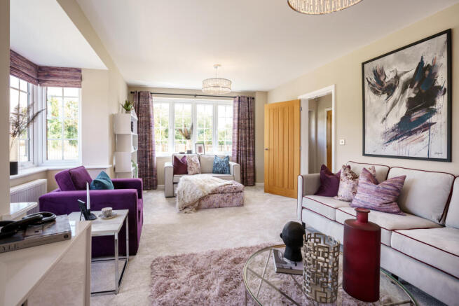 A modern living room with plush purple and grey furniture in the foreground and a large abstract pai