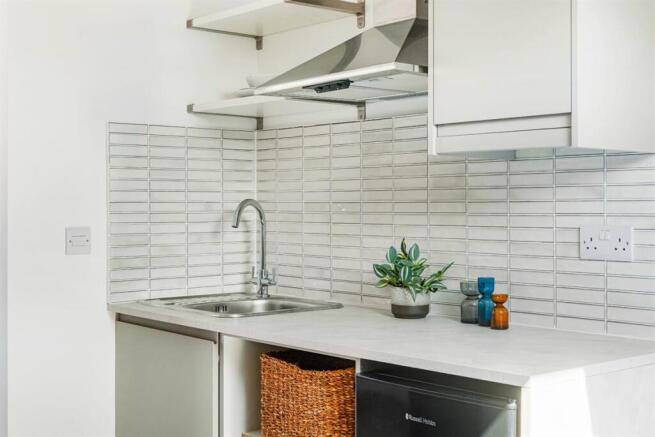 Bright and modern kitchenette with tiled splash...