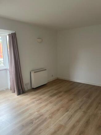 Bright, neutral living room with wood-effect fl...
