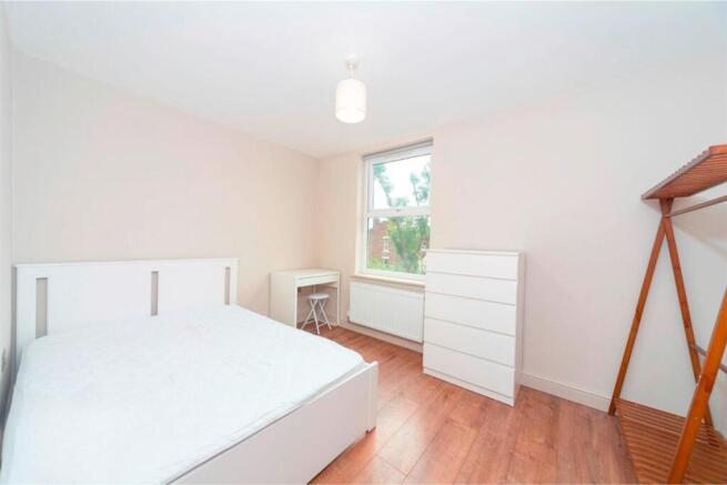 Bright furnished bedroom with white furniture...