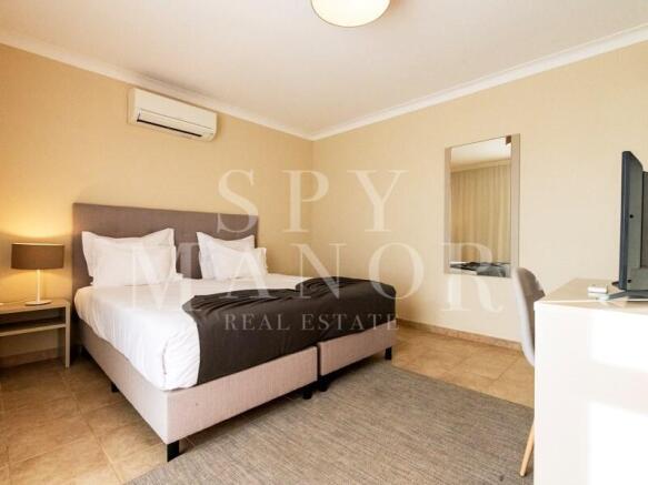Elegant master bedroom with AC in a triplex apartment for sale at Gramacho Golf Resort, Carvoeiro, Algarve. Fully furnished interior.