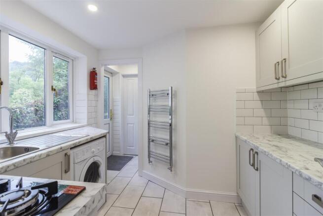 Modern kitchen with marble tops and bright wind...