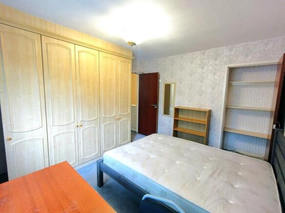 Bright, well-equipped bedroom featuring extensi...