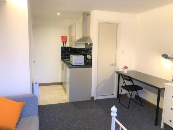 A bright and tidy single bedroom featuring a co...