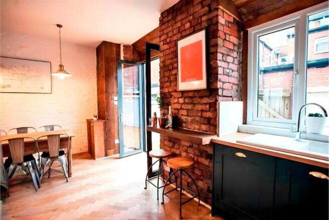Stylish open-plan kitchen with exposed brick...