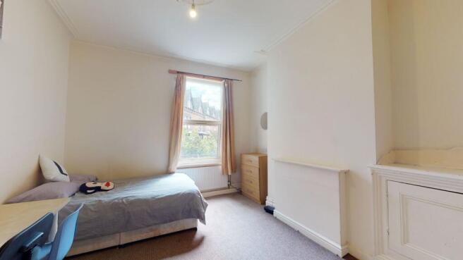 A bright and cozy bedroom featuring a single be...