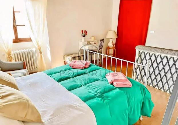 Cozy bedroom with a vibrant green bedspread and ch