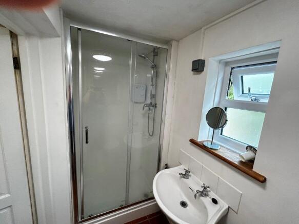 Bright bathroom with walk-in shower and window...