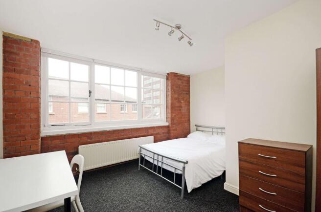 Bright furnished bedroom with large industrial-...