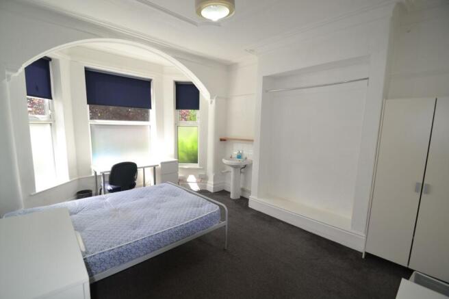 Bright and airy bedroom featuring a large windo...