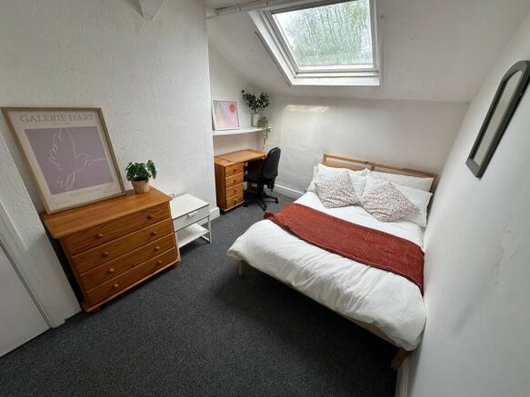 A bright and cozy bedroom featuring a double be...