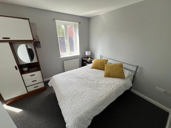 A bright and tidy double bedroom featuring a co...