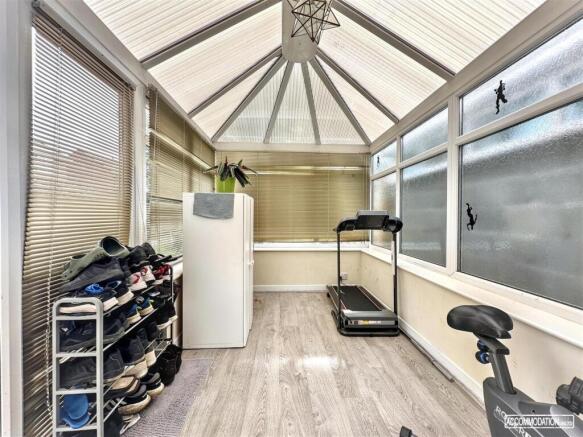 Bright sunroom equipped with home gym machines...