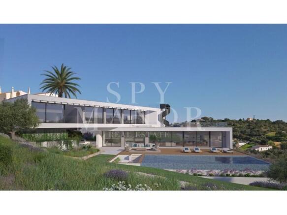 Modern architectural luxury villa exterior in Carvoeiro Algarve with large glass windows sun terrace and private swimming pool