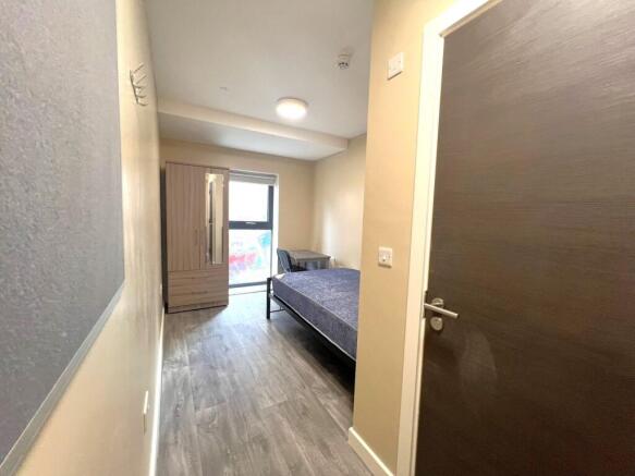 A clean, well-lit bedroom featuring a single be...