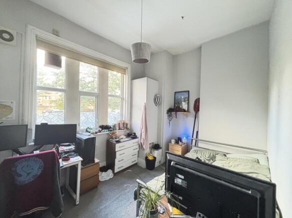 The bedroom features a comfortable bed, a desk ...
