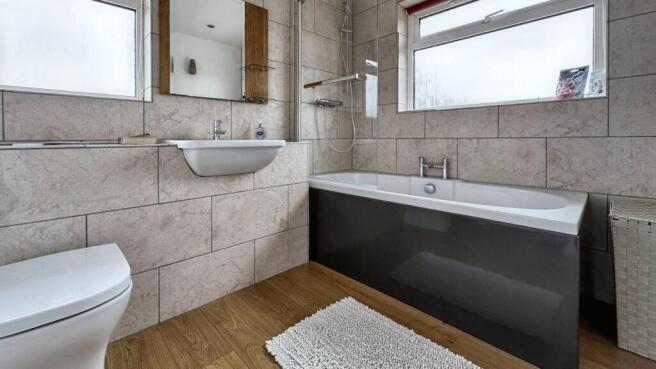 Modern bathroom with stylish tiles and bathtub...