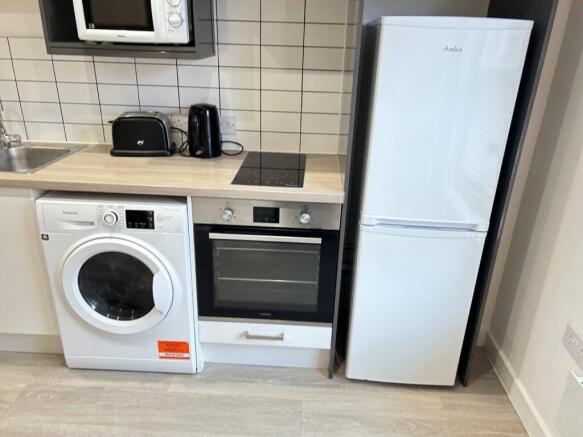 Modern kitchen with full appliances and tiling...