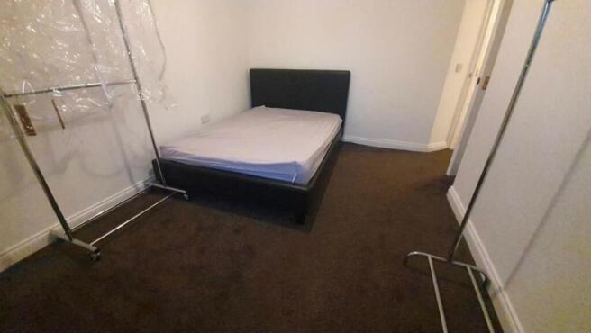 Spacious bedroom featuring a large double bed...