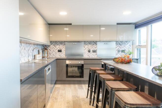 Modern fully fitted kitchen with sleek grey cab...